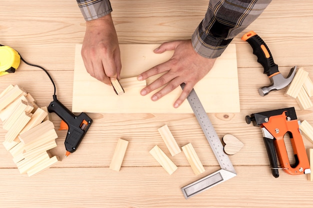 Operaio del falegname creando decorazioni per la casa in legno nella sua officina