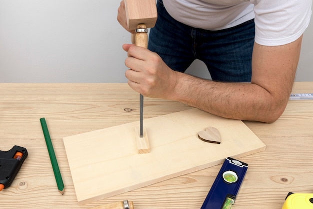 Operaio del falegname creando decorazioni per la casa in legno nella sua officina