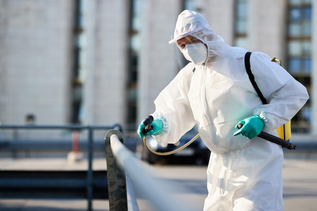 Operaio disinfettante che pulisce le strade della città durante la pandemia COVID19