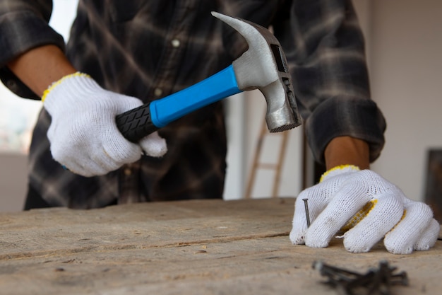 Operaio edile che usa il martello nel luogo di lavoro