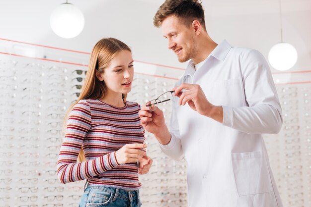 Optometrista che consiglia donna che sceglie i vetri