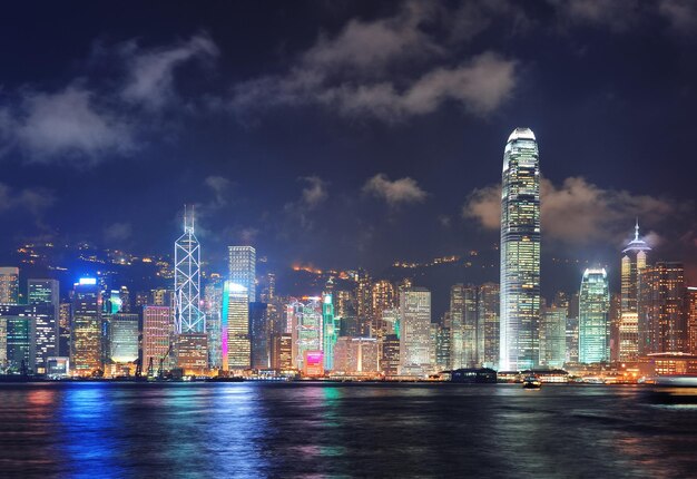 Orizzonte di Hong Kong di notte con le nuvole sopra il porto di Victoria.