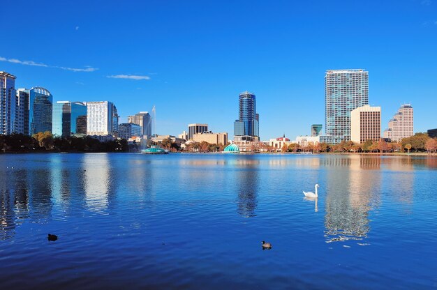 Orlando Lake Eola al mattino con grattacieli urbani e cielo azzurro con cigno.