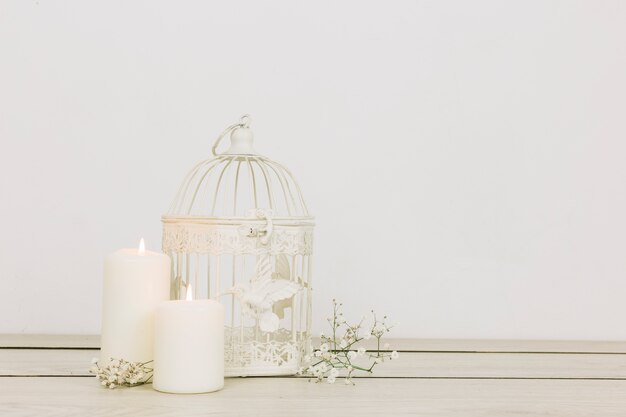 Ornamenti romantici con candele e gabbia