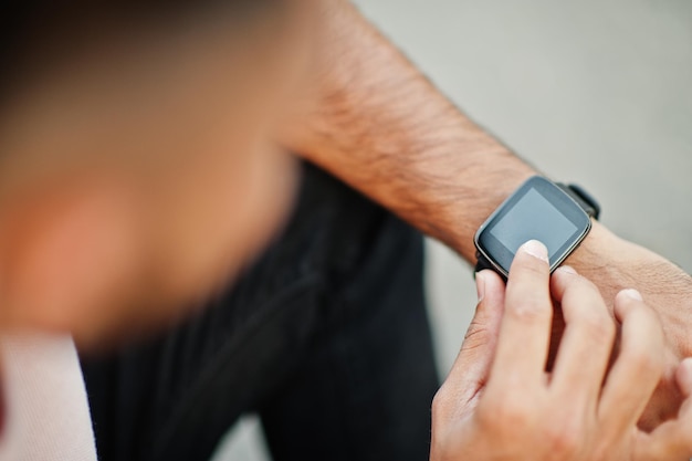 Orologio nero intelligente sulla mano del ragazzo dall'alto