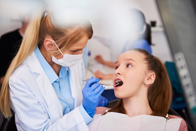 Ortodontista femminile che esamina i denti del bambino