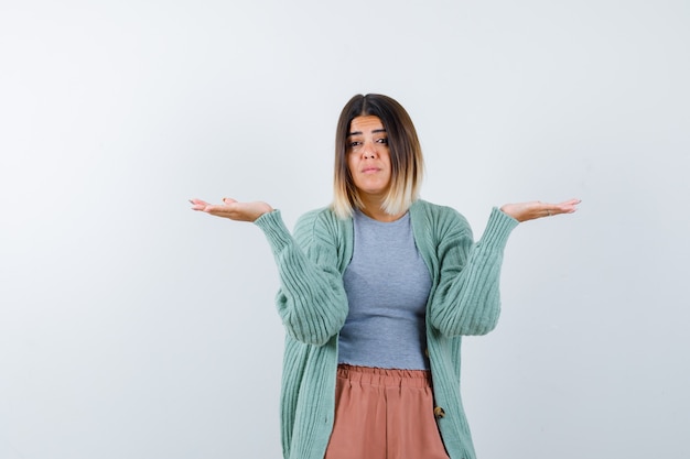 Ortrait di donna che mostra gesto impotente in abiti casual e guardando perplesso vista frontale