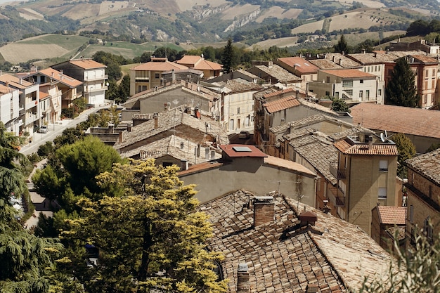 Osservi da sopra ai tetti rossi di vecchia città italiana