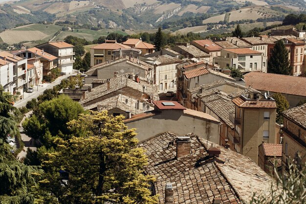 Osservi da sopra ai tetti rossi di vecchia città italiana