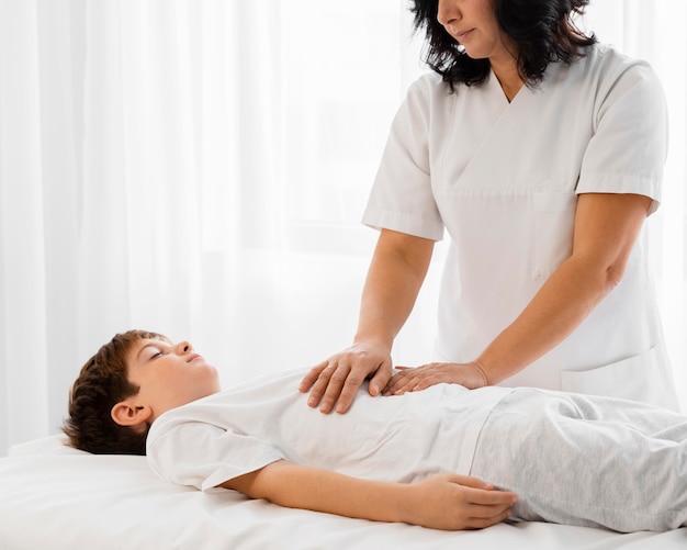 Osteopata che cura un bambino massaggiandogli la pancia