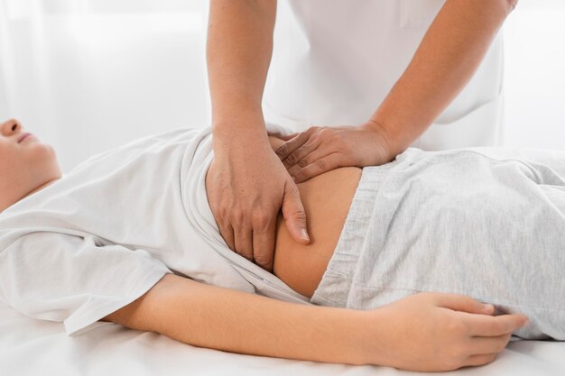 Osteopata che cura un bambino massaggiandogli la pancia