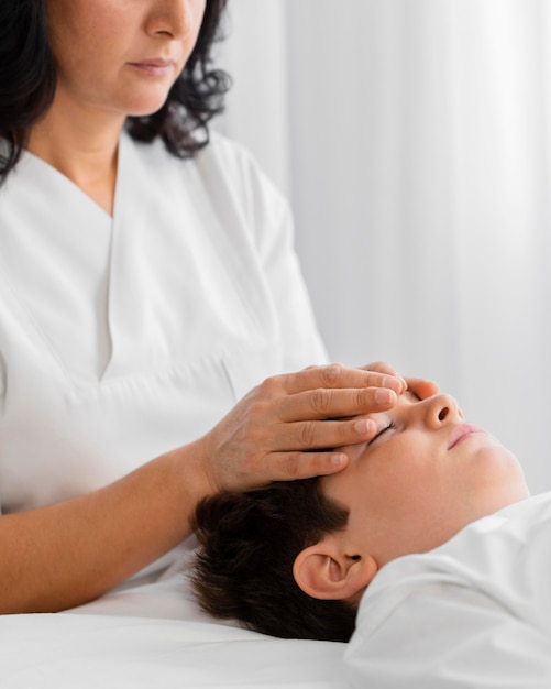 Osteopata che cura un bambino massaggiandogli la testa