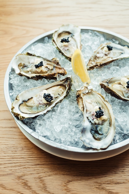 Ostrica cruda e fresca con caviale in cima e limone