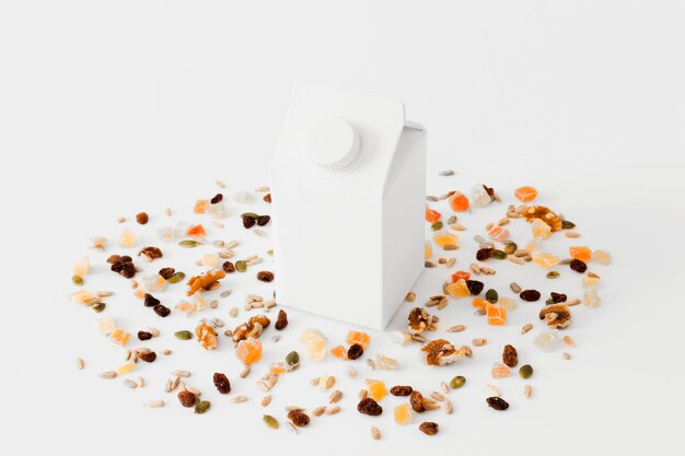 Pacchetto di cartone bianco tra frutta secca e noci