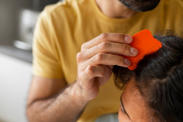 Padre aiutando il ragazzo con i pidocchi ad alto angolo