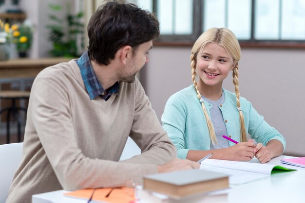 Padre che fa da tutor per sua figlia al chiuso