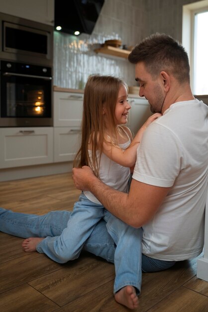 Padre che fa ridere sua figlia facendole il solletico