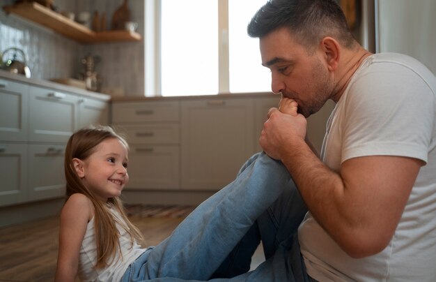 Padre che fa ridere sua figlia facendole il solletico