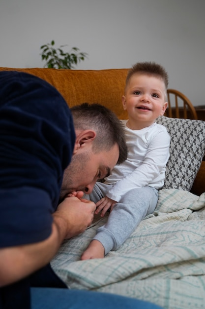 Padre che fa ridere suo figlio facendogli il solletico