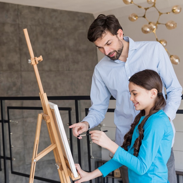 Padre che insegna alla ragazza a dipingere