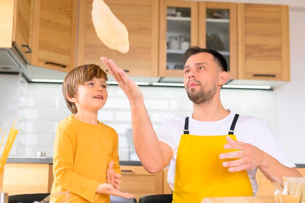 Padre che lancia la pasta in aria