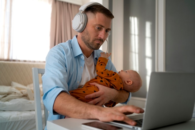 Padre che lavora da casa cercando di bilanciare la vita familiare con il figlio e il lavoro