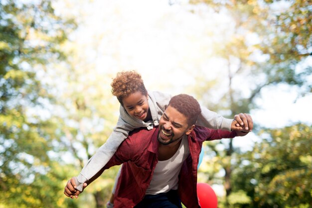 Padre che tiene sua figlia sulle spalle e ridendo