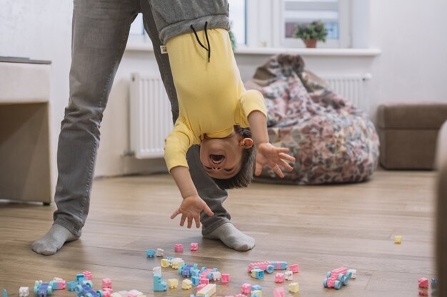 Padre che tiene suo figlio sottosopra