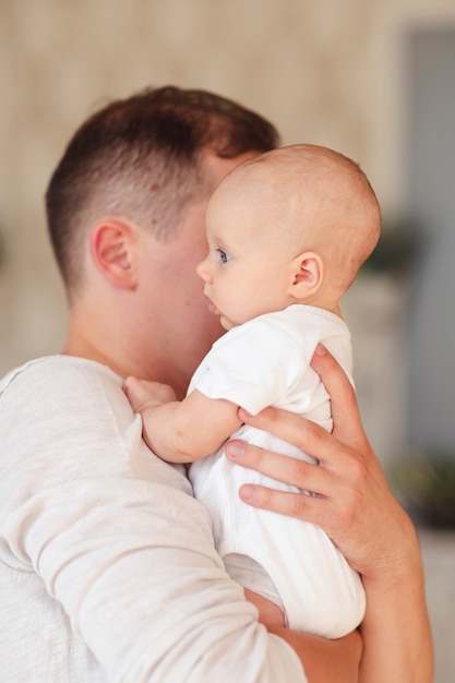 Padre che tiene vista laterale del bambino adorabile