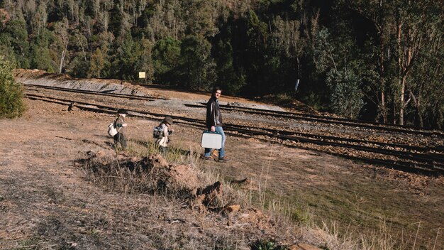 Padre con bambini che camminano verso la ferrovia