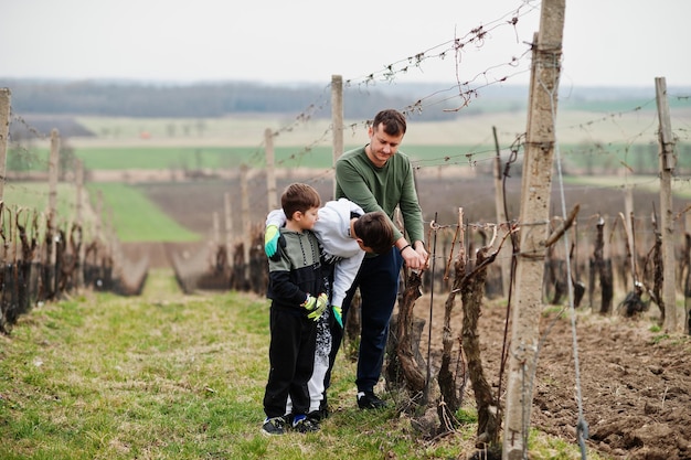 Padre con due figli che lavorano in vigna