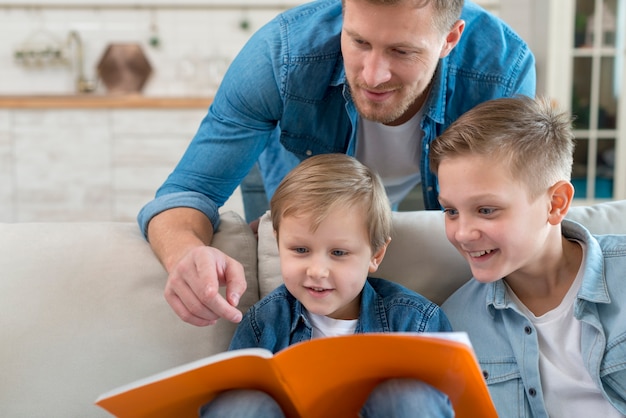 Padre con i fratelli che leggono insieme