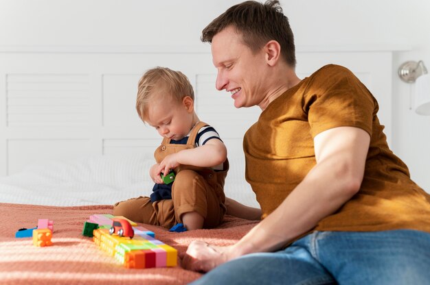 Padre del colpo medio che guarda il gioco del bambino