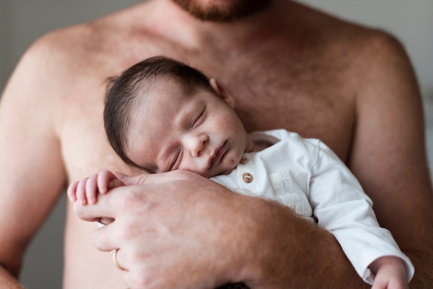 Padre del primo piano che tiene il suo bambino assonnato