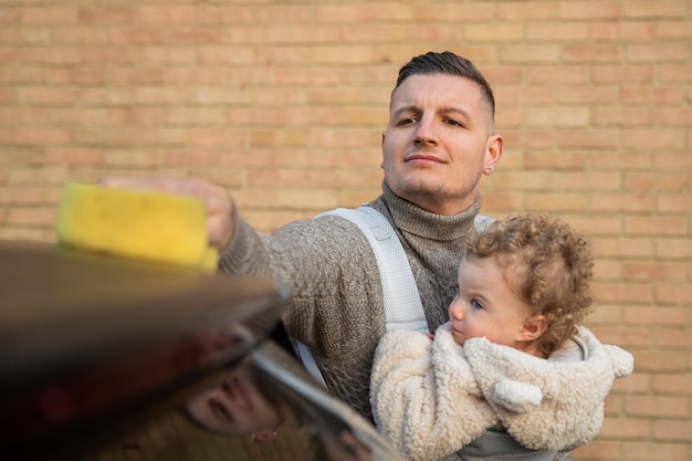 Padre di vista frontale con l'automobile di lavaggio del bambino