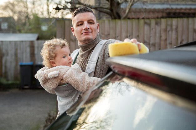 Padre di vista frontale con l'automobile di lavaggio del bambino