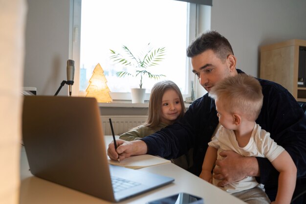 Padre di vista laterale che lavora con i bambini a casa