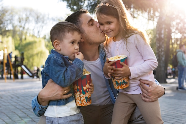 Padre e bambini di tiro medio nel parco