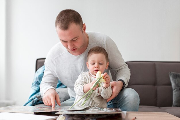 Padre e bambino con libro e fiori