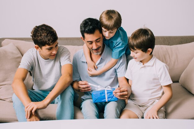 Padre e figli sul divano il giorno di padri