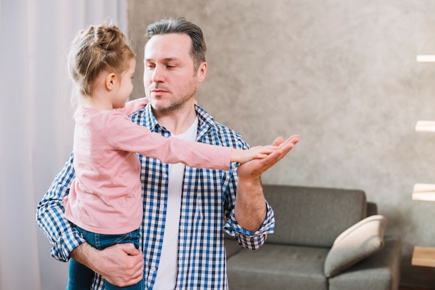 Padre e figlia che giocano gioco d&#39;applauso mentre se lo esaminano