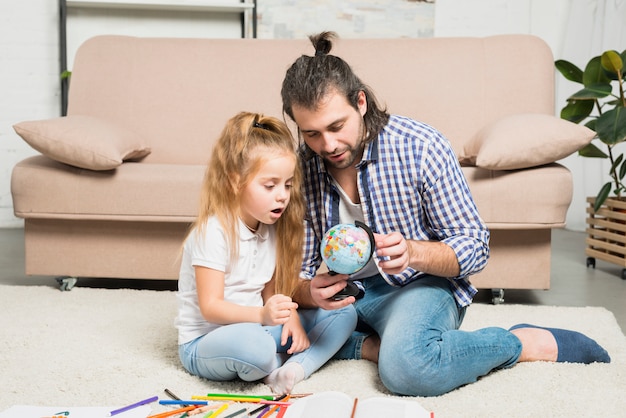 Padre e figlia guardando il globo