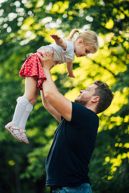 Padre e figlia obliqui che giocano nel parco