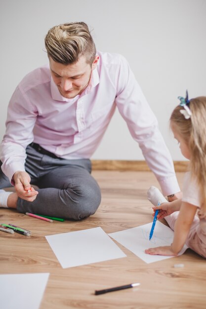 Padre e figlia seduti sul disegno del pavimento