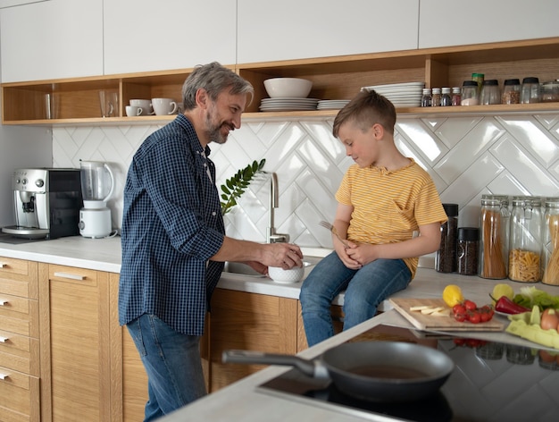 Padre e figlio a tiro medio che cucinano