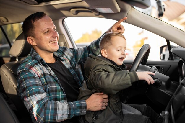 Padre e figlio che giocano con la ruota dell'auto