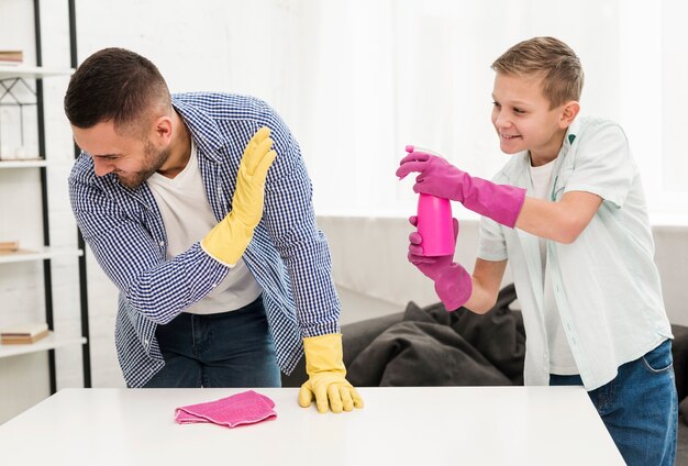 Padre e figlio che giocano insieme mentre puliscono la casa