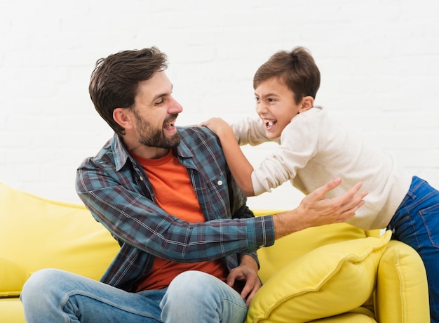 Padre e figlio che giocano sul divano