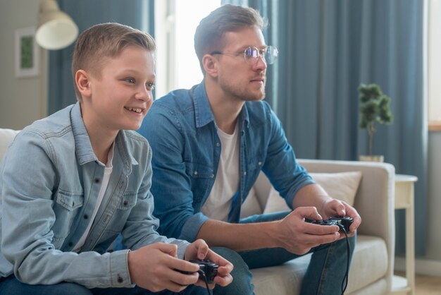 Padre e figlio che giocano vista laterale dei videogiochi