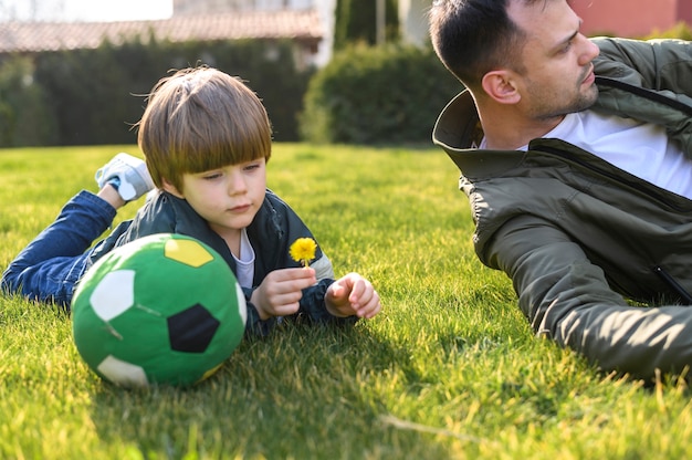 Padre e figlio che pongono sull'erba